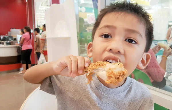 Asijské boy jíst smažené kuře. — Stock fotografie