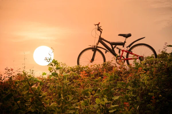 Mountainbike met een kleurrijke lucht en zonsondergang. — Stockfoto