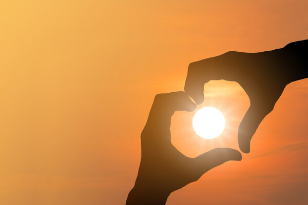 Силуэт сделанного вручную сердца символизирует солнце
.