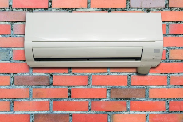 Aire acondicionado de pared colgando de una pared de ladrillo . — Foto de Stock