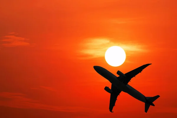 Silhouette flygplan och av röd himmel — Stockfoto