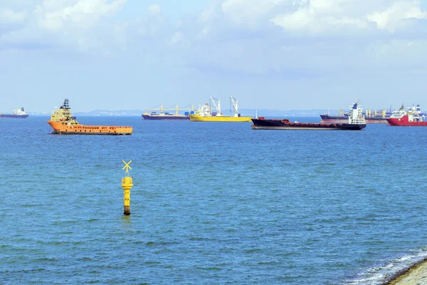 Lastfartyg förankrade längs havsstranden — Stockfoto