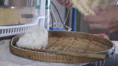 Buharda pişirilmiş glutinous pilavını bir bambu tepsisine koy ki ısı yayılsın..
