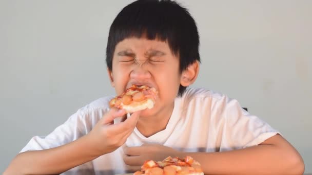 Ασιατικό Χαριτωμένο Αγόρι Λευκό Πουκάμισο Κάθεται Χαρούμενα Τρώει Πίτσα — Αρχείο Βίντεο