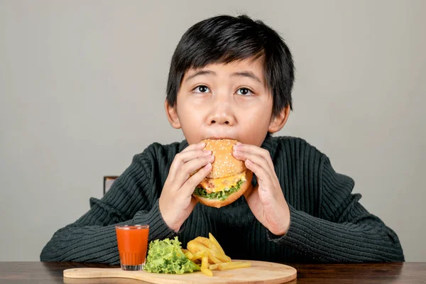 Lindo Chico Asiático Comiendo Una Deliciosa Hamburguesa Con Felicidad — Foto de Stock