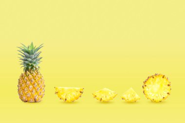 Grup ananas koleksiyonu ve sarı pastel arka planda izole edilmiş dilimler..