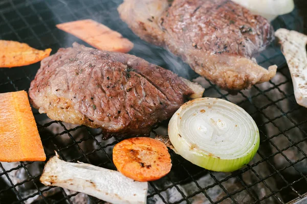 스테이크를 요리하기 숯불에 쇠고기를 담근다 — 스톡 사진