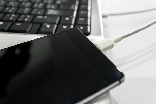 Connectez le smartphone au portable par câble USB . — Photo