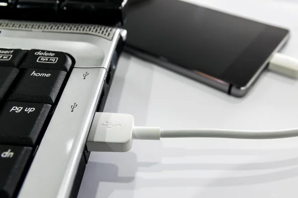 Conecte o smartphone ao notebook por cabo USB . — Fotografia de Stock