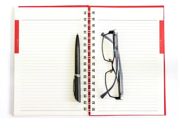 Στυλό και γυαλιά σε ένα τετράδιο. — Φωτογραφία Αρχείου