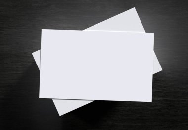 Siyah ahşap zemin üzerine istiflenmiş beyaz isim kartlarının üst görünümü, üç boyutlu resimlendirme