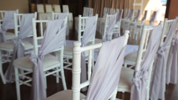 Centrándose en la tela púrpura claro arco está atado a una silla de madera en blanco. En — Vídeo de stock