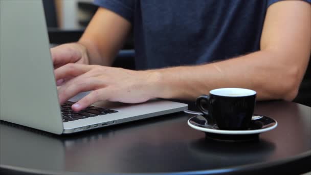 Człowiek w koszulce wpisując tekst dwa ręce na laptopie jabłko — Wideo stockowe
