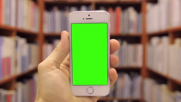 Telefone inteligente na biblioteca Tela verde capotando — Vídeo de Stock