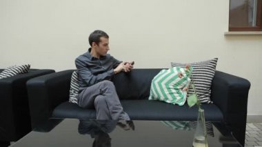 Adam akıllı telefon ve kanepede oturan