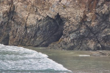 Sisli bir günde Big Sur 'da Sand Dollar Plajı' nda yürüyüş ve sörf.