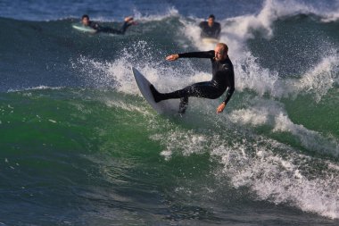 Leo Carrillo Eyalet Plajı 'nda büyük yaz dalgalarında sörf.