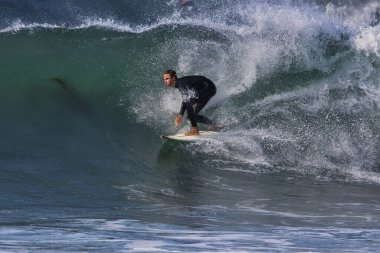 Leo Carrillo Eyalet Plajı 'nda büyük yaz dalgalarında sörf.
