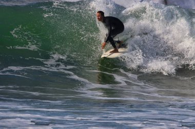 Leo Carrillo Eyalet Plajı 'nda büyük yaz dalgalarında sörf.