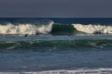 Leo Carrillo Eyalet Plajı 'nda büyük yaz dalgalarında sörf.