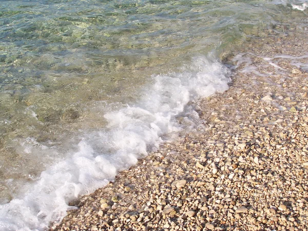 海浪冲击鹅卵石海滩和岩石 — 图库照片