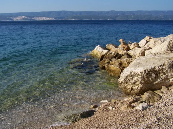 Plage croate avec rochers géants et petits cailloux — Photo