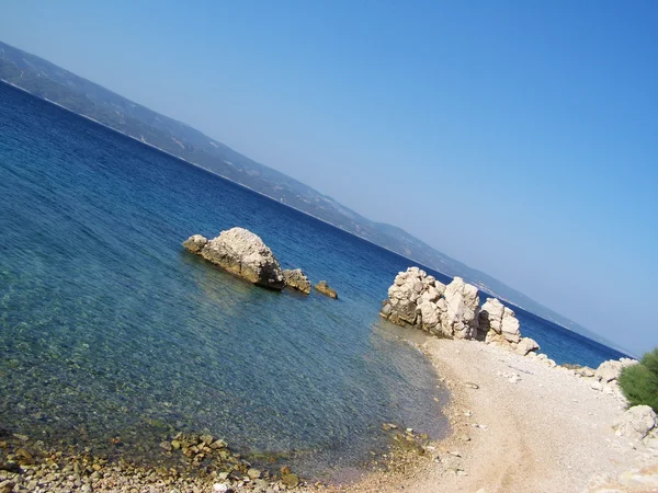 Хорватский пляж с гигантскими скалами и мелкой галькой — стоковое фото