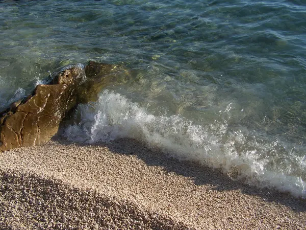 海浪冲击鹅卵石海滩和岩石 — 图库照片