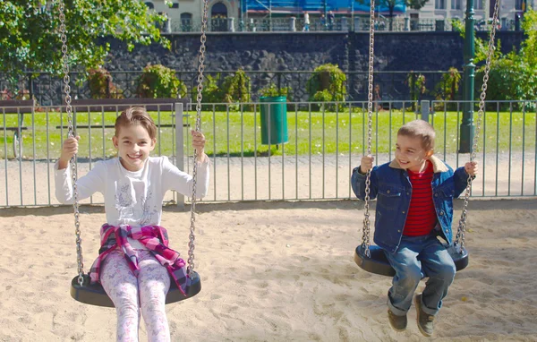 İki küçük çocukla bir salıncak üzerinde