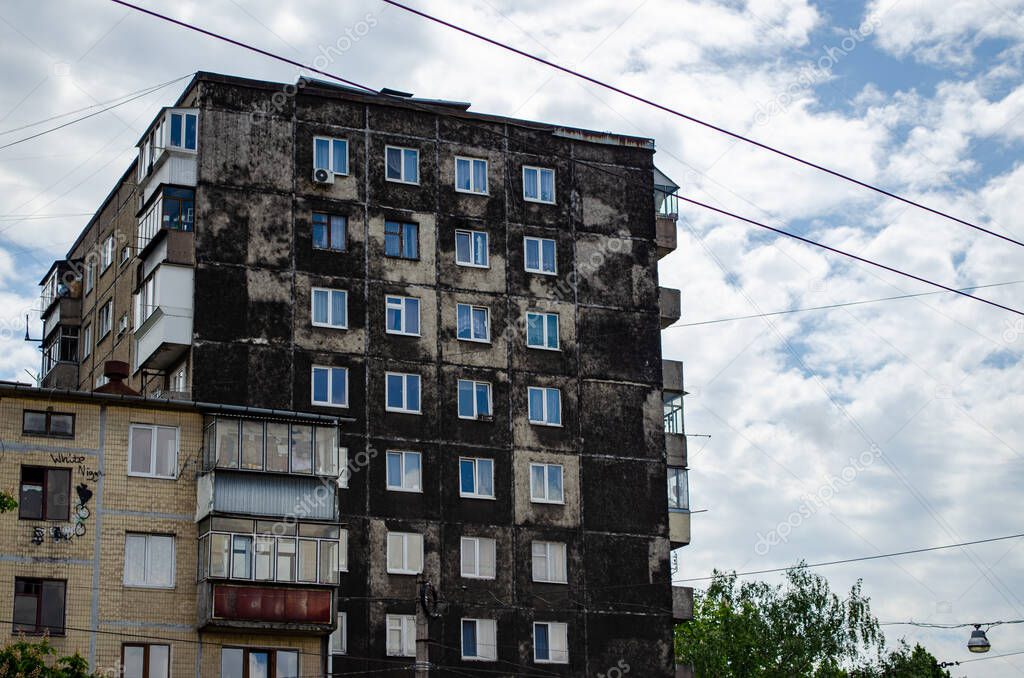 Semi-dark facade of shabby apartment building of a multi-storey Soviet panel house in Lviv.