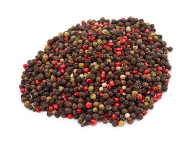 Beyaz arka planda izole edilmiş siyah kırmızı beyaz ve yeşil biber içeren büyük bir yığın biber..