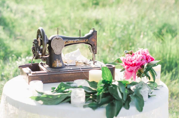 Sewing machine and pink peony flowers — Stock Photo, Image