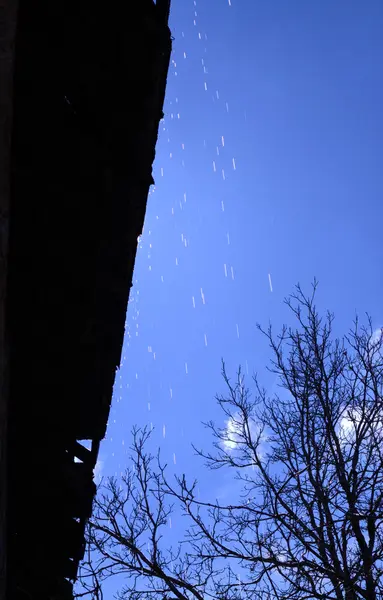 La nieve se derrite y gotea desde el techo en primavera — Foto de Stock