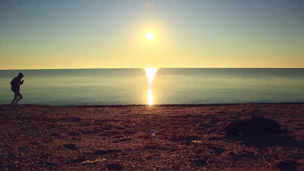 Silhouet van sport actieve man uitgevoerd en uitoefenen op het strand bij zonsondergang. — Stockvideo