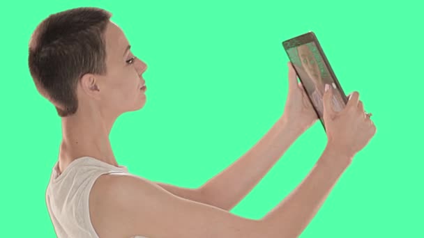 Bella ragazza calva, con i capelli corti bruna sullo schermo verde, prendendo selfie con tablet digitale — Video Stock