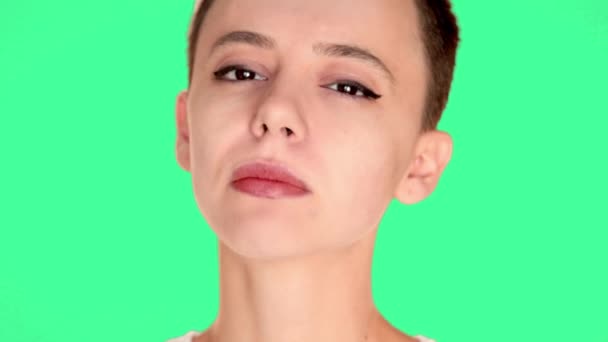 Hermosa chica calva, una chica con pelo corto morena en la cara de pantalla verde. Chica joven caucásica de cerca retrato. labios rojos, piel, dientes. Captura de estudio  . — Vídeo de stock