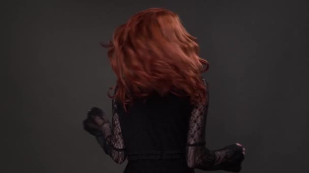 Gadis berambut merah berputar-putar di depan kamera di studio — Stok Video