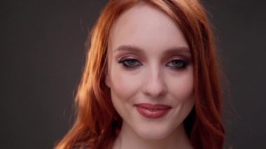 Kızıl saçlı kadın. 25-30 yaşlarında. Yüzü yakın plan. Dişlerinle gülümse. Cilt bakım ürünleri reklamı. İfade kırışıklıkları. Gözlerinin altına ateş et. Yaşlanan makyaj.