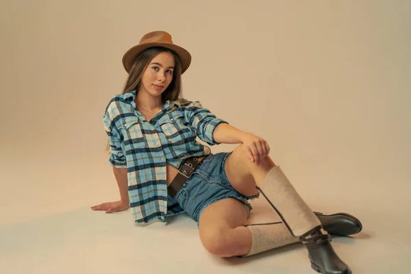 Girl in plaid shirt and cowboy hat on pink background Royalty Free Stock Images