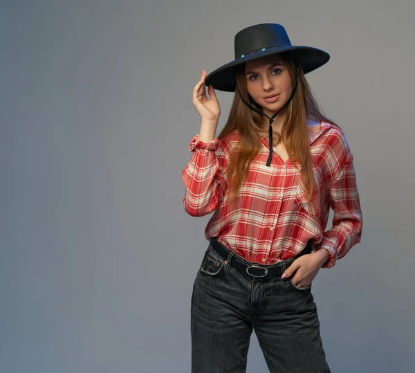 Meisje in geruite shirt en cowboy hoed op roze achtergrond Rechtenvrije Stockfoto's