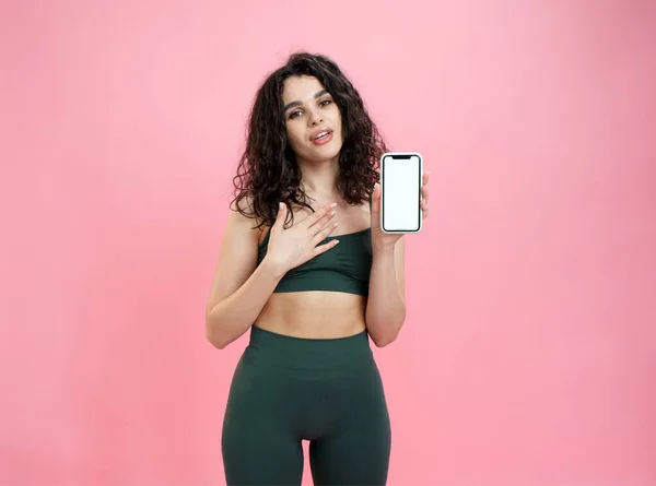 Sportif kız pembe arka planda fitness mobil uygulaması reklamları yapıyor.