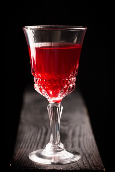Egy pohár vörösbor egy fa asztalon. — Stock Fotó