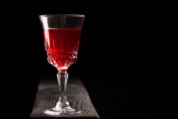 एक लकड़ी की मेज पर लाल शराब का ग्लास — स्टॉक फ़ोटो, इमेज