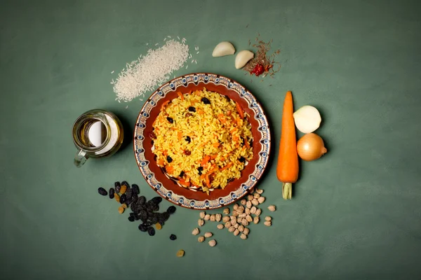 Plate of oriental pilaf on the green background — Stock Photo, Image