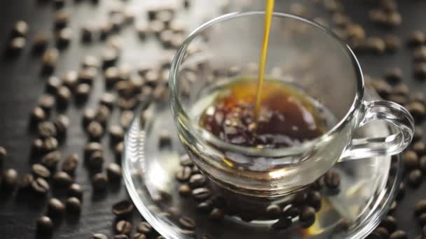 Pouring hot black coffee into transparent cup — Stock Video