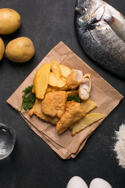 Traditionelle britische Fish and Chips auf dunkler Oberfläche — Stockfoto