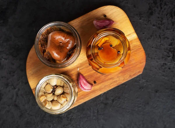ニンニクとコショウで缶詰のキノコとガラス瓶 暗い背景で発酵食品 — ストック写真