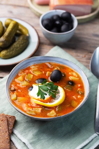 Solyanka, Russian soup with sausage, olives, pickled cucumber and capers — Stock Image Solyanka Russian Soup Sausage Olives Pickled Cucumber Capers Royalty Free Stock Images