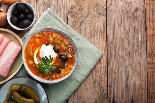 Solyanka, Russian soup with sausage, olives, pickled cucumber and capers. Top view with copy space — Stock Image Solyanka Russian Soup Sausage Olives Pickled Cucumber Capers Top View Stock Image