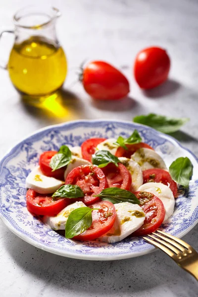 Caprese salad. Italian famous salad with fresh tomatoes, mozzarella cheese and basil — Stock Photo, Image